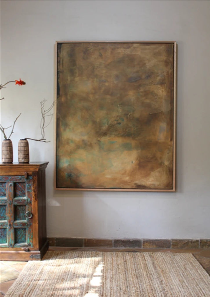 Large abstract painting on a wall in a room with a wooden cabinet and decorative items.