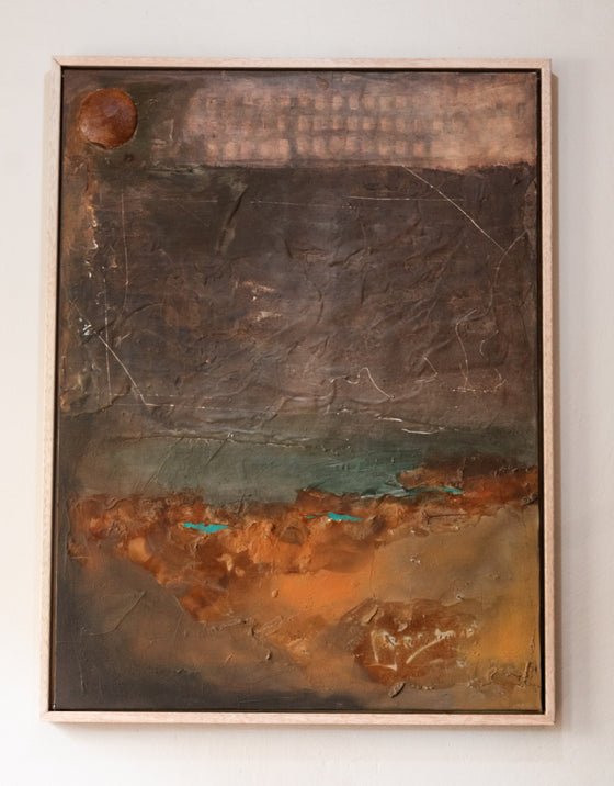 Abstract textured painting in a wooden frame on a white wall