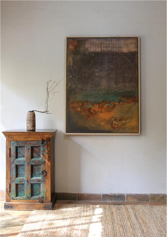 Abstract textured painting in a wooden frame on a white wall