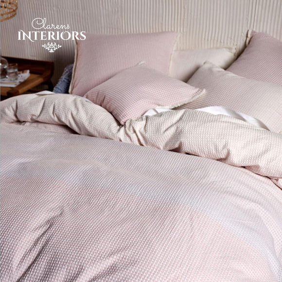 Lucca Blossom duvet cover set. Reminiscent of a coastal romance, Lucca enjoys a softly toned ombre in graduating hues of warm white and blossom pink on a beautifully woven and textured waffle ground. This cotton beauty is trimmed with fringing and reverses to a plain-dyed cotton.